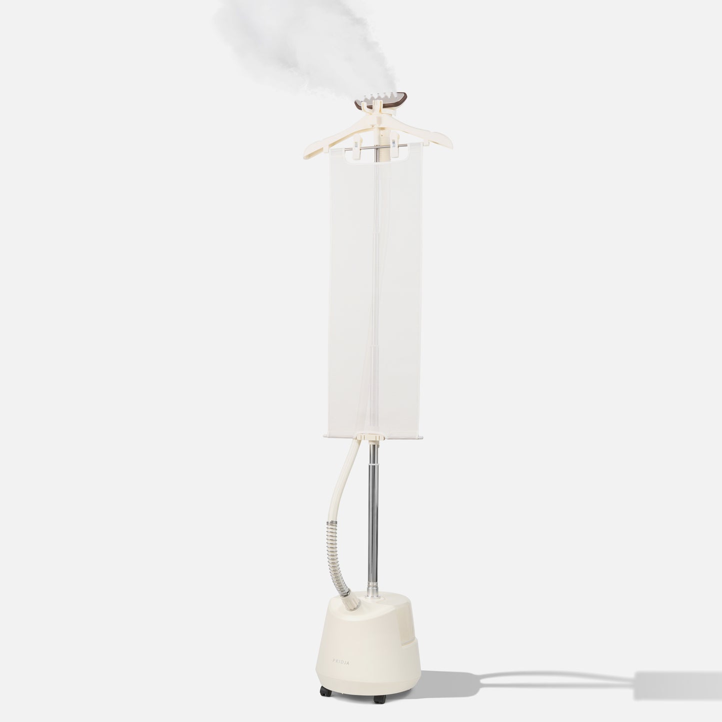 A white vertical clothes steamer with a hanger on top, releasing steam. The device has a water tank at the base, a long pole, and a hose attached to the steaming head, all set against a plain light background.