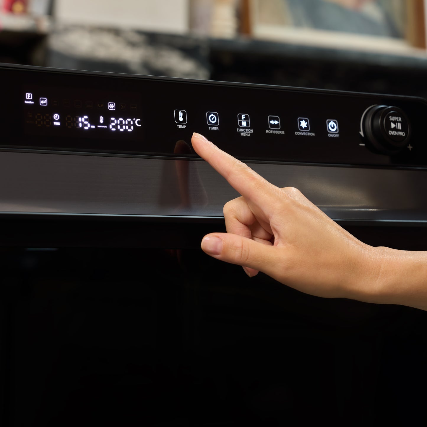 A hand uses the touch control panel on the Fridja f77 Super Oven Pro - 30L Digital Air Fryer Oven, selecting a temperature of 200°C as the digital display and function icons light up.
