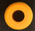 A Fridja f1900 Seal Ring, yellow and circular with a central hole like a thick washer, is shown resting on a dark surface.