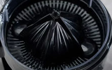 Close-up of the Fridja f800 Dome Automatic Citrus Juicer in black, featuring a ridged conical reamer and circular strainer for pulp and seeds, designed for maximum juice extraction.