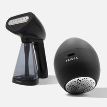 The Fridja Garment Care Duo - f10 and f40, featuring a sleek black handheld steamer with a transparent water tank and a spherical fabric shaver, form a stylish set against a plain light background.