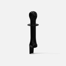 The Fridja f2500 Pusher - Updated Design, a black plastic tool with a round hollow top, wide circular middle, and flat angled base, stands upright on a white background for efficient juicing.