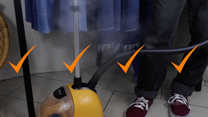 A yellow garment steamer emits steam near a person wearing rolled-up jeans and red sneakers. Three orange check marks are overlaid on the image. Blue clothes hang in the background.