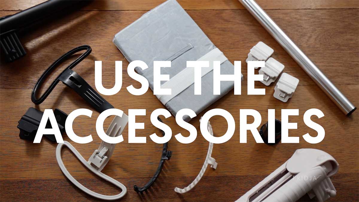 Assorted white and black plastic accessories, a metal rod, and a wrapped rectangular object arranged on a wooden surface, with the text USE THE ACCESSORIES overlaid in bold white letters.