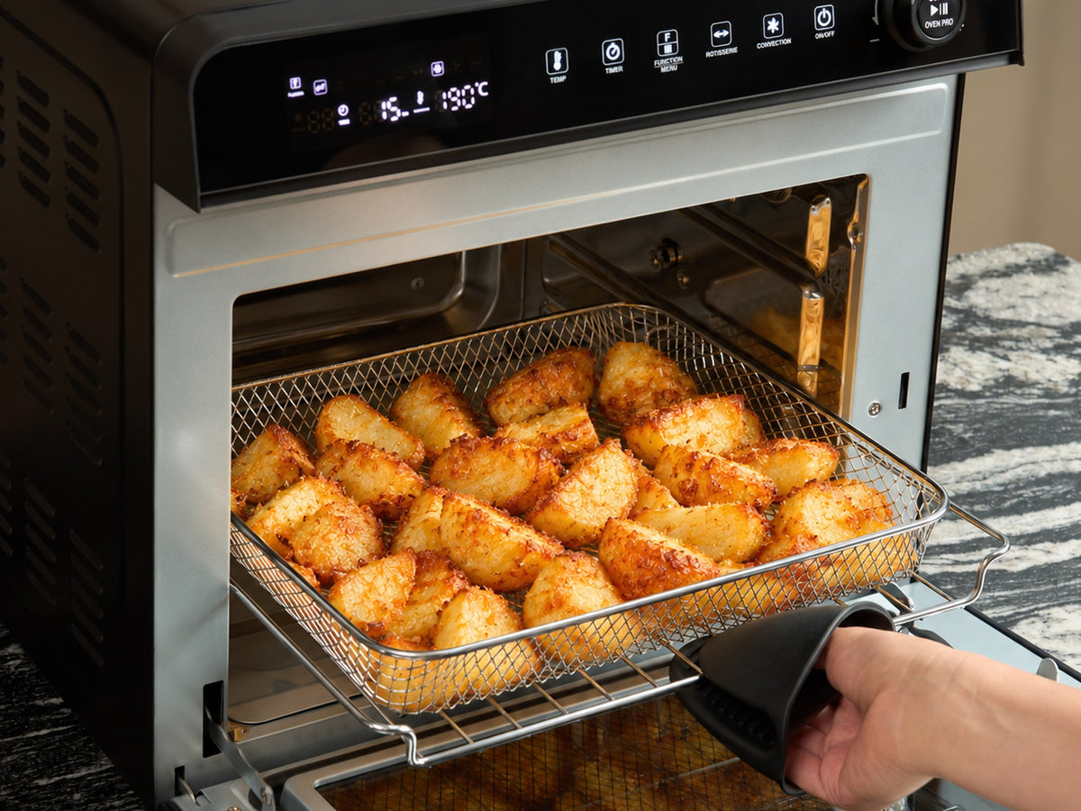 Crispy roast potatoes in the air fry basket being lifted out of the Fridja f77 Super Oven Pro air fryer oven