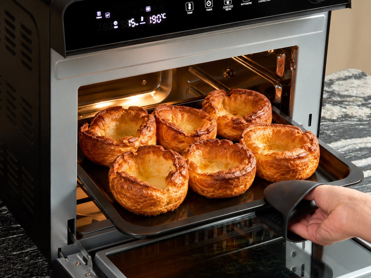 Six tall, golden Yorkshire puddings on a tray coming out of the Fridja f77 Super Oven Pro air fryer oven