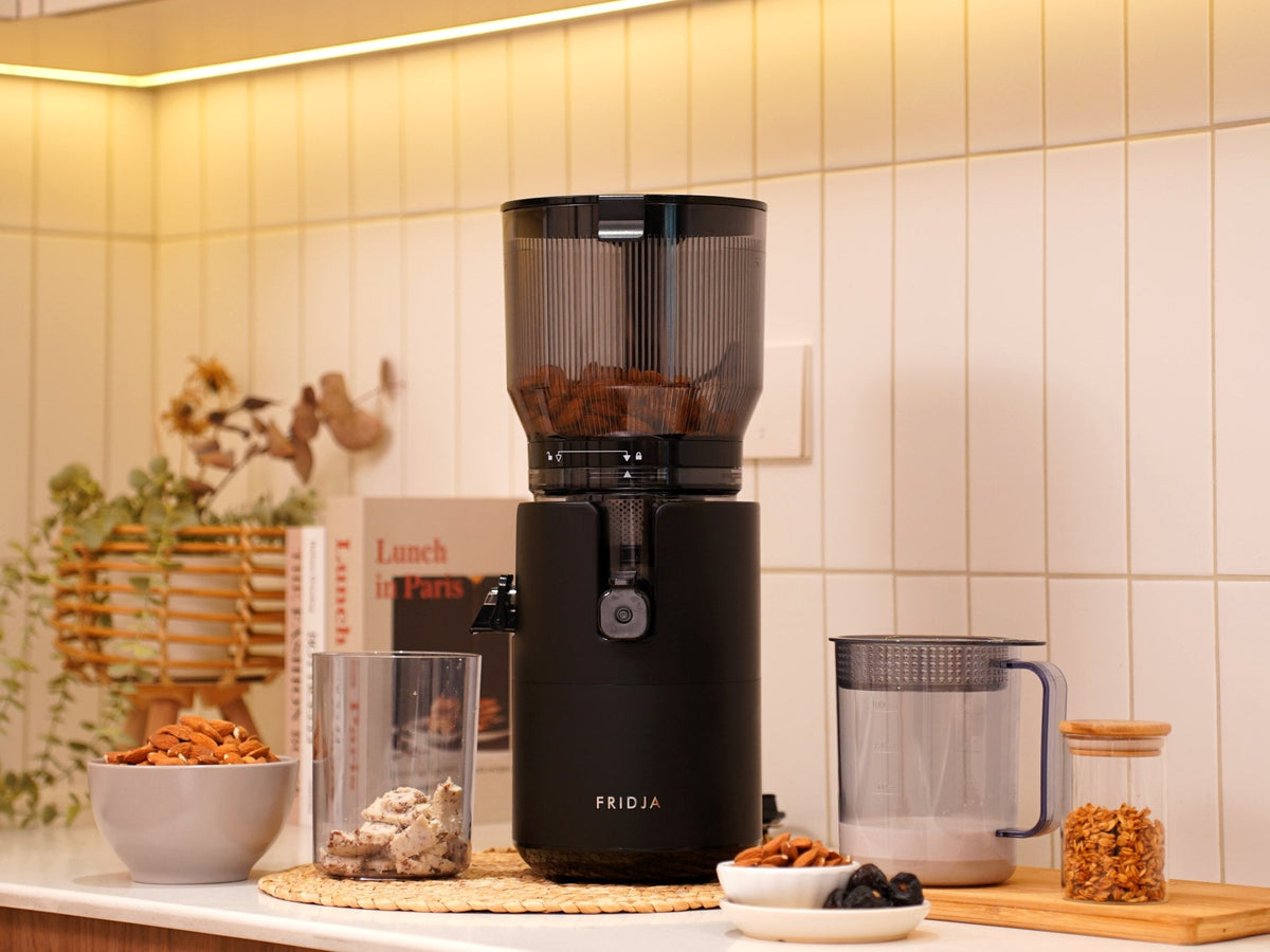 Fridja f2800 Open Whole Fruit Juicer on a kitchen worktop with a juice jug and fresh ingredients