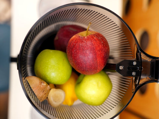 Whole apples, lemon and ginger loaded into the hopper of the Fridja f2500 Self Feeding Whole Fruit Juicer