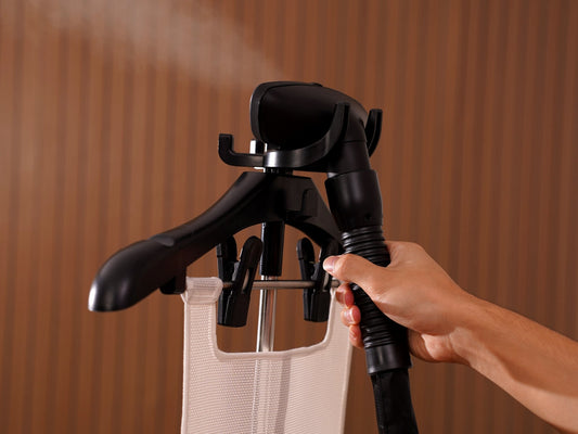 Fridja f1200 Clothes Steamer Pro steaming a knitted top hung on its built-in hanger
