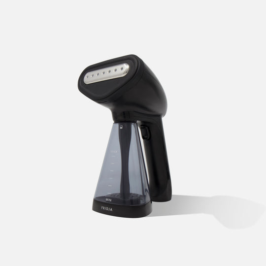 A black handheld garment steamer with a transparent water tank, featuring a visible water level indicator, standing upright on a white background.