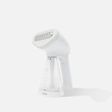 The Fridja f10 Handheld Clothes Steamer - Refurbished Grade A features a white design with a transparent MIN/MAX water tank, standing upright—ideal for at-home garment care or as a travel-friendly steamer.