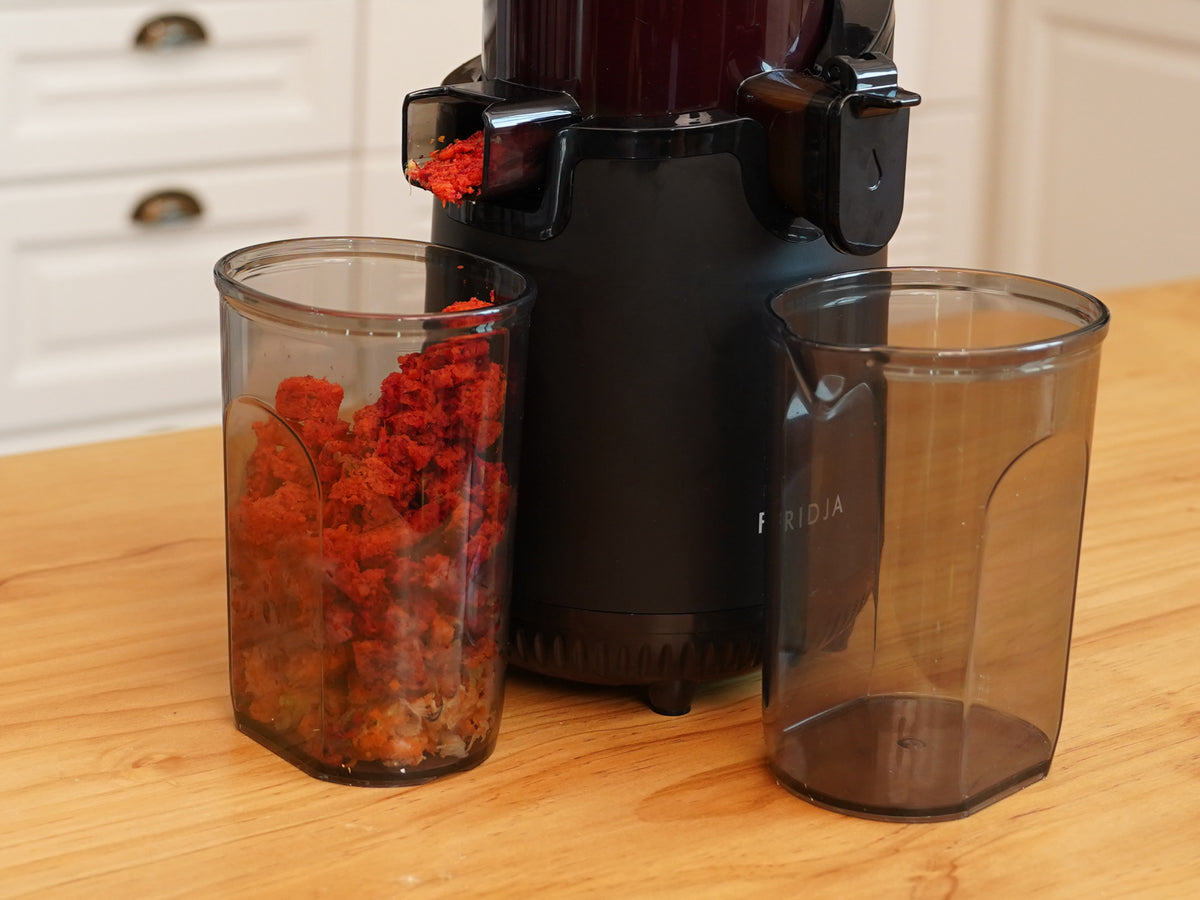Fridja f2500 juicer with separate pulp and juice jugs on a wooden worktop
