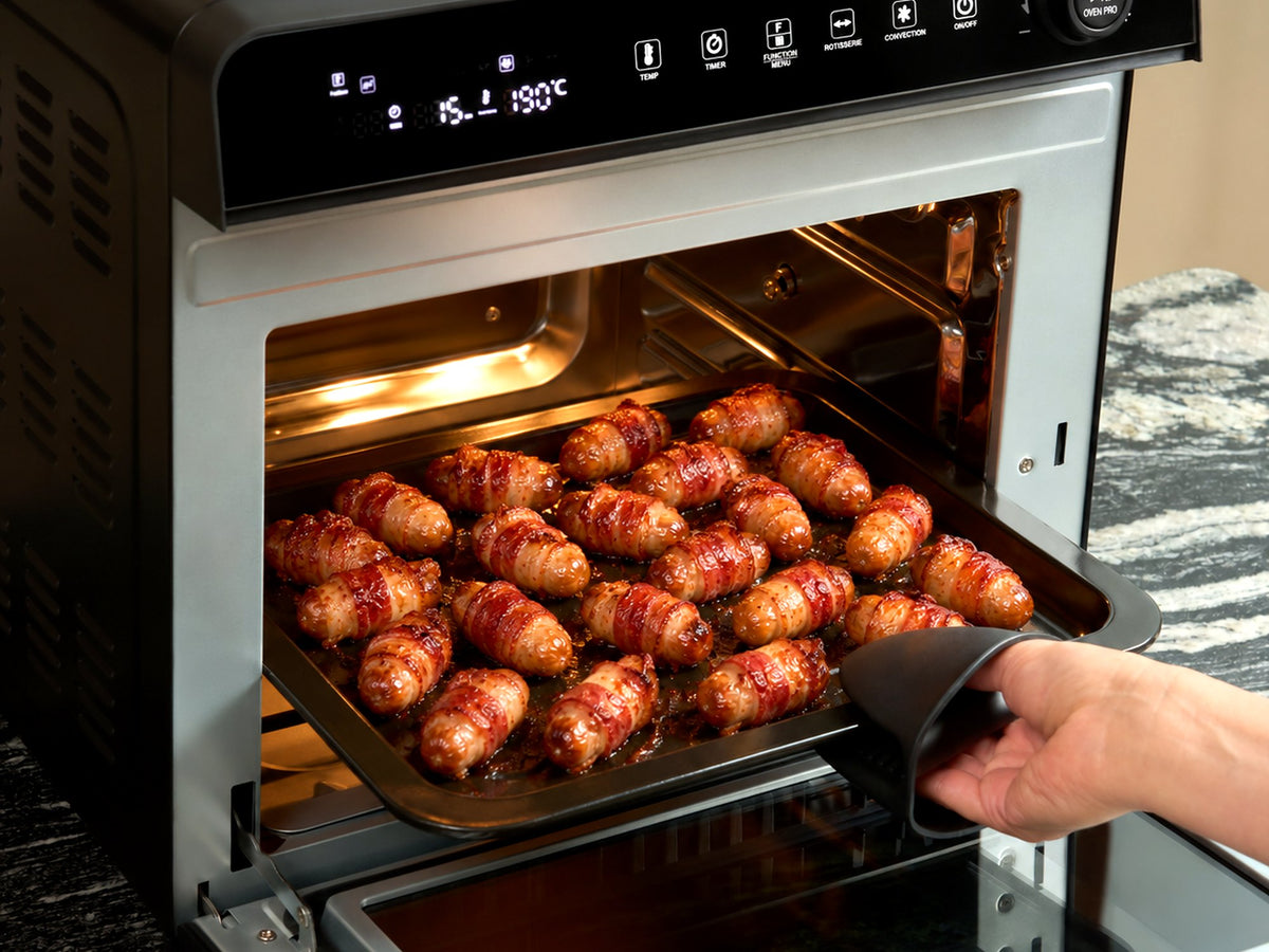 A tray of crispy pigs in blankets being lifted out of the Fridja f77 Super Oven Pro air fryer oven at 190°C