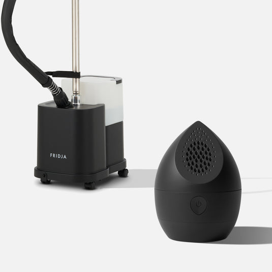 The Fridja Commercial Garment Care Duo – f1600 Steamer and f40 Fabric Shaver, in sleek black with modern features, are displayed against a plain white background, showcasing advanced garment care solutions.