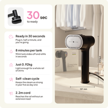 The Fridja f20 Handheld Clothes Steamer Pro with Suction, shown in sleek black on a table, is highlighted by text showcasing its features: it heats up in just 30 seconds, provides up to 8 minutes of steaming per tank, weighs only 0.92kg, offers a convenient self-clean cycle, includes a generous 2.2m cord for easy reach, and measures 275x137x125mm.
