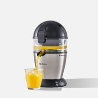 The Fridja f900 Automatic Citrus Juicer - Refurbished dispenses fresh orange juice into an ice-filled glass, shown against a plain white background.