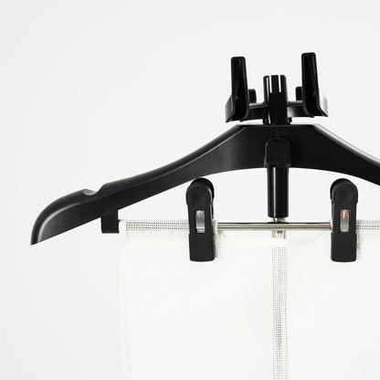 The Fridja Flexible Ironing Board with Clothes Hanger and Pegs securely holds garments, making it perfect for use with commercial clothes steamers to maintain a crisp, professional look against a plain white background.