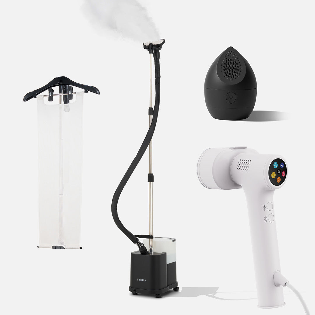 Four household gadgets—the Fridja f1600 Commercial Clothes Steamer with a hanging cover, the sleek black egg-shaped Fridja air purifier, and the white Fridja f20 Handheld Clothes Steamer Pro with digital controls—are all displayed on a white background. They make ideal companions for your laundry routine, especially when paired with essentials like the Fridja Flexible Ironing Board and f40 Fabric Shaver from the Commercial Garment Care Kit.