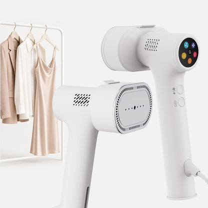 The Fridja f20 Handheld Clothes Steamer Pro with Suction in white, featuring a digital display, is displayed from two angles. Behind it, a dress and a blazer hang on a rack, demonstrating the steamer’s versatility and efficiency as a modern alternative to traditional ironing.