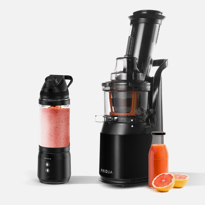 The Fridja Portable Blender/Juicer Duo - f500 and f1900, shown in black with a juice container, a bottle of orange juice, halved grapefruit, and a blender bottle with pink smoothie, displayed on a white background.