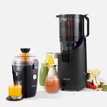 Two black Fridja juicers, the Juicer Duo - f800 and f2500, are displayed with fruit, juice, and bottles. The left f800 squeezes orange juice into a glass; the right f2500 stands tall with apples inside, surrounded by fruit, ice cream, and juice bottles.