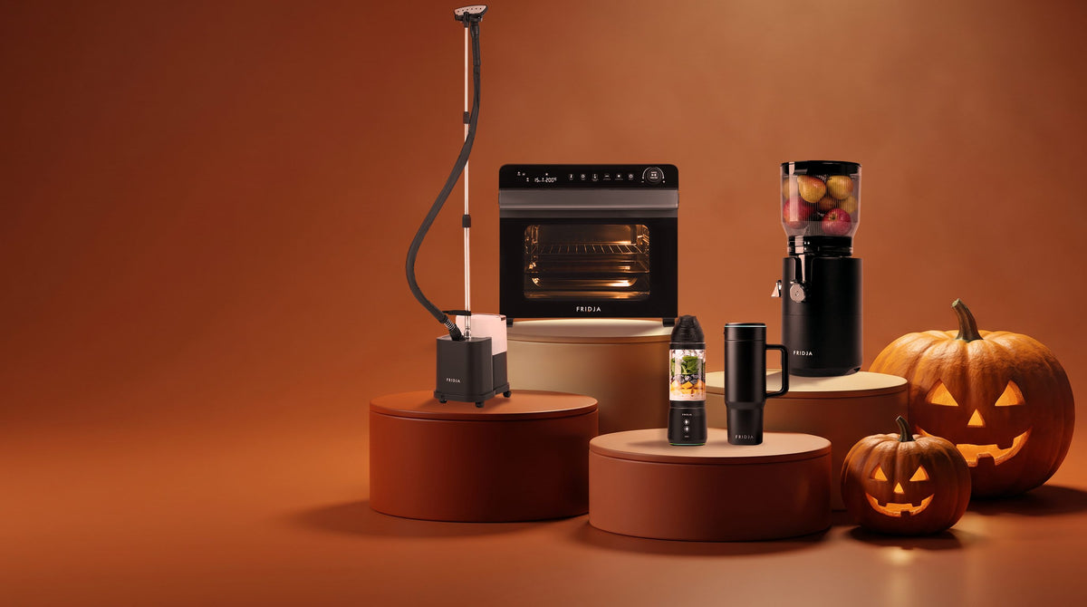 Fridja f2800 Open Juicer, f77 air fryer oven, f1200 steamer, f600 blender and travel mug on podiums with jack-o'-lanterns